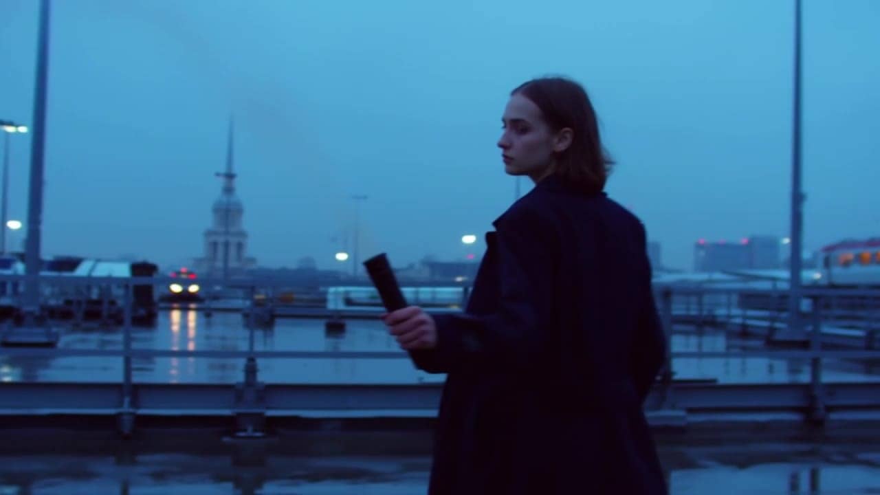Ejemplo de video IA de Luma Ray 2 Flash: **Scene (plain language):** A stylish young woman in modern streetwear stands alone on a rain-sl...