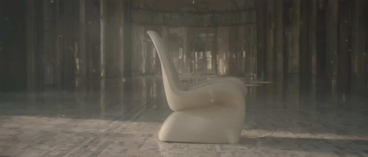 Luma Ray 3.2 AI video example: A quiet editorial shot of a sculptural cream chair in a sunlit gallery, slow lateral camera move, soft flo...
