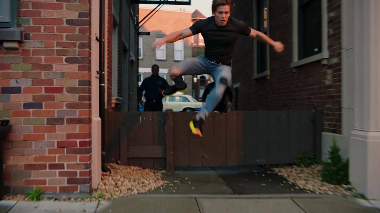 Ejemplo de video IA de Kling 2.5 Turbo: Cinematic, hyper-realistic action sequence filmed with a professional handheld camera. A man runs...