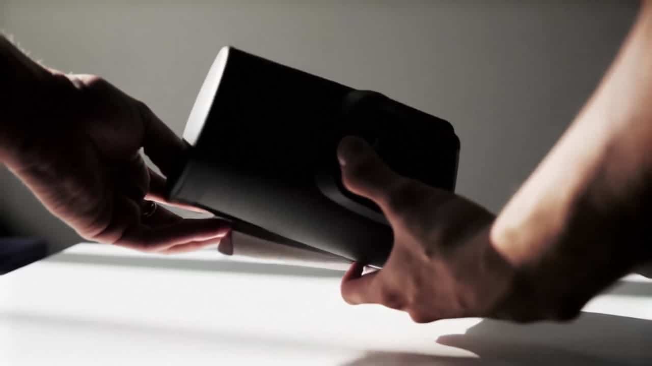 Ejemplo de video IA de LTX Video 2.0 Fast: Product demo video on a clean tabletop, two human hands unbox a matte black coffee grinder, ro...