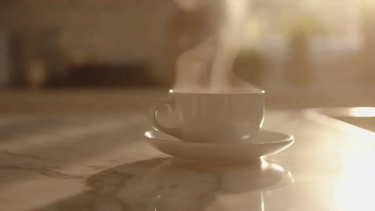 OpenAI Sora 2 AI video example: 8 second cinematic commercial featuring a young woman in her early 30s enjoying a morning coffee at home...