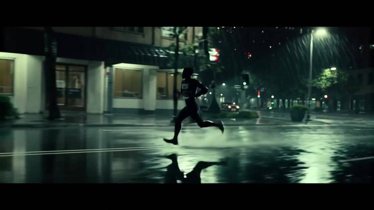 Exemple video IA LTX Video 2.0 Pro: Wide 16:9 cinematic action shot, a runner sprints through a rainy city street at night, water splashe...