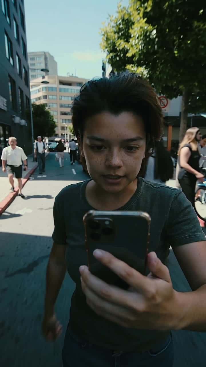 Kling 2.5 Turbo AI video example – Ultra-realistic walking selfie shot filmed with a smartphone held in one hand. The person is speed-walking through a…