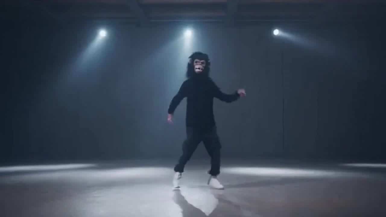 OpenAI Sora 2 AI video example: A man wearing a gorilla head costume dances alone in a room under flickering strobe lights. There are sev...