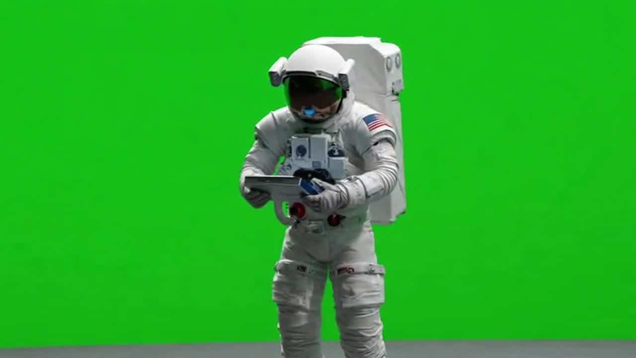 OpenAI Sora 2 AI video example: green screen astronaut standing, examining an instrument and looks on.
